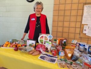 A woman poses with groceries.