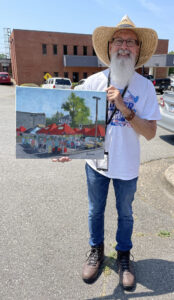 Man poses with a painting of farmers market.