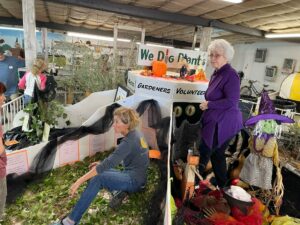 Women work a plant display at a fair.